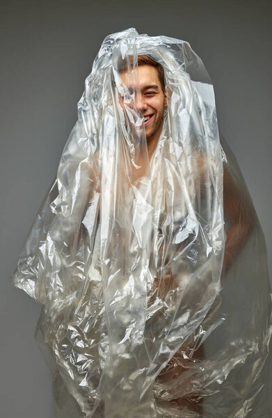 Смешной мужчина наслаждаться жизнью в грязи среди пластиковых пакетов