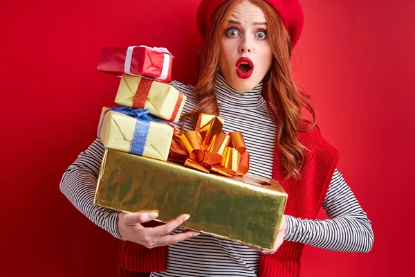 Эмоциональная рыжая леди приятно удивлена, получив так много подарков — стоковое фото