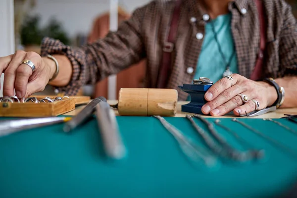 Experimentado orfebre joven que trabaja en una joyería hecha a mano en un taller, recortado — Foto de Stock