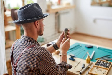 Mücevherci, iş yerindeki masaüstünde otururken takıları mükemmelleştirir.