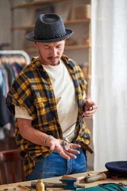 Yakışıklı profesyonel kuyumcu. Ellerinde el yapımı bir zincir tutuyor.