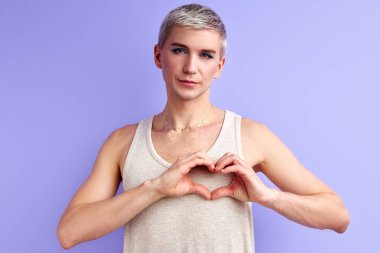 Erkek manken sevişir, kameraya el ile yapılan kalbi gösterir.