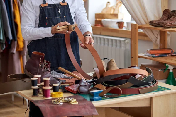 Jeune artisan cultivé en tablier travaillant avec le cuir à l'atelier — Photo