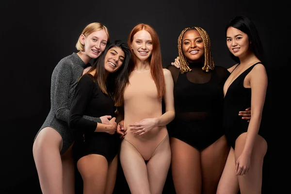 Портрет пяти улыбающихся смеющихся красивых женщин в телесном костюме, стоящих вместе — стоковое фото