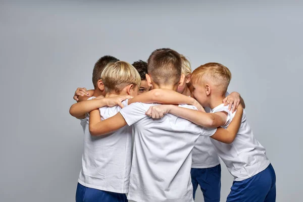 Ryhmä teini pojat kokoontuivat puhumaan ottaa levätä jalkapallopelin aikana — kuvapankkivalokuva