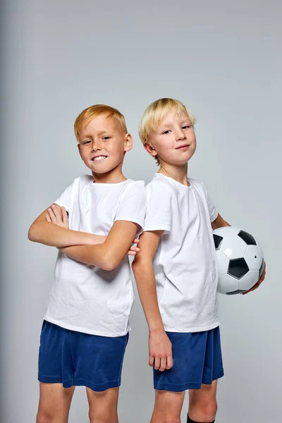 Portret van twee Kaukasische voetballers jongens die rug aan rug staan — Stockfoto