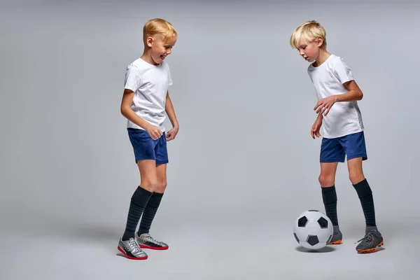 Crianças jogar futebol isolado no estúdio — Fotografia de Stock