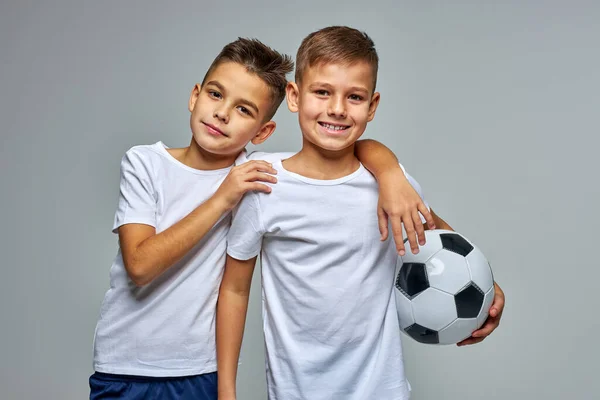 Meninos ativos amigáveis com bola de futebol nas mãos — Fotografia de Stock