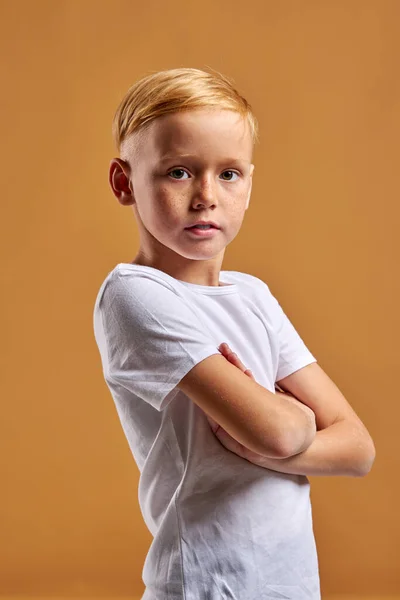 Petit caucasien taches de rousseur garçon stand avec les bras croisés posant — Photo