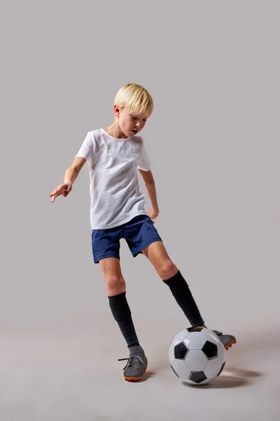 Jovem jogador de futebol menino jogando com bola, chutando — Fotografia de Stock