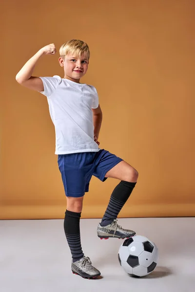 Retrato de caucasiano jovem jogador de futebol menino posando com bola no estúdio — Fotografia de Stock
