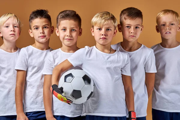 Pohledný kavkazský dětský chlapecký tým fotbalistů shromážděných po zápase — Stock fotografie