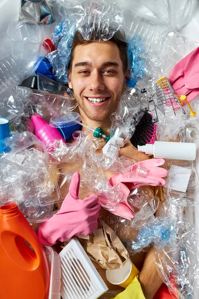 Uomo positivo godere di annegamento sotto i destinatari di plastica mucchio, spazzatura, spazzatura — Foto Stock