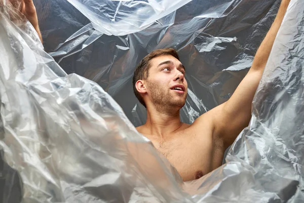 Jovem com sacos de plástico no corpo — Fotografia de Stock