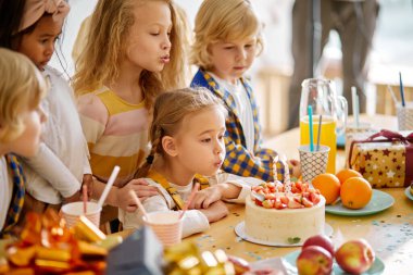 Çeşitli çocuklar evde arkadaşının doğum gününü kutluyorlar.