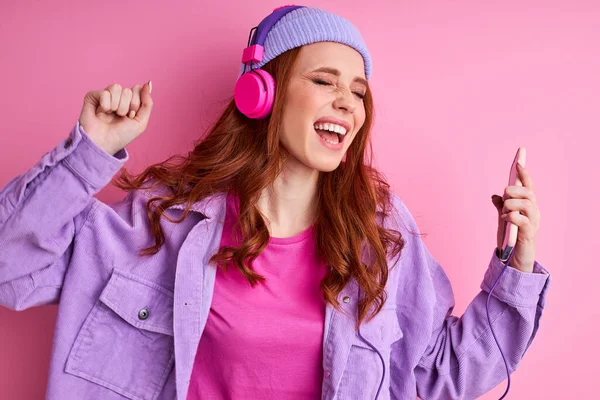 Feliz pelirroja mujer bailar y cantar canciones, escuchar música aislada —  Fotos de Stock