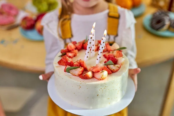Köstlich dekorierte Geburtstagstorte mit Kerzen in den Händen von Mädchen — Stockfoto