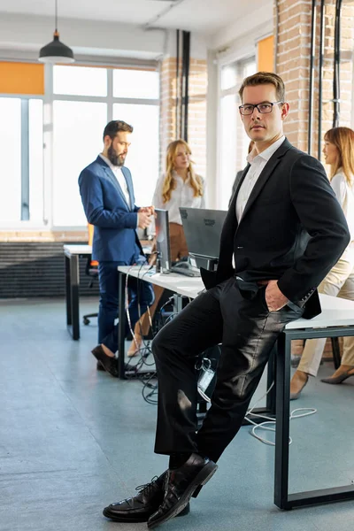 portrait of successful caucasian businessman in suit posing at camera in office