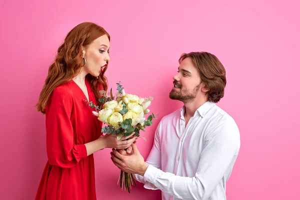 Pareja celebrando el Día de San Valentín, hombre con flores dando a la mujer — Foto de Stock