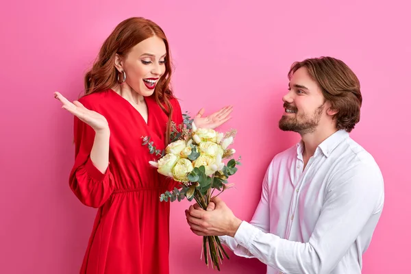 Date romantique : caucasien gars présentant des fleurs à jeune rousse dame — Photo