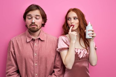 pretyy caucasian woman holding whipped cream in hands, smeared cream on guys nose clipart