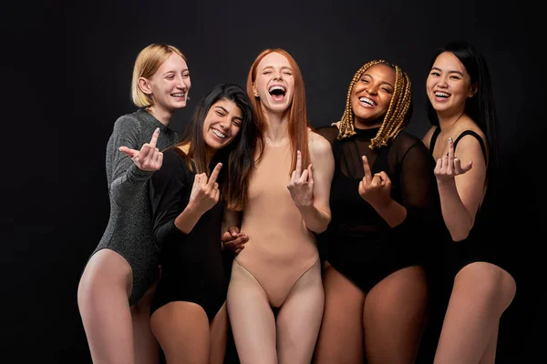 Portrait of careless caucasian african and asian women showing FUCK gesture — Stockfoto