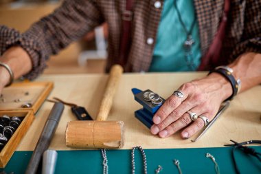 Kuyumcu profesyonel aletlerle mücevher yapıyor.