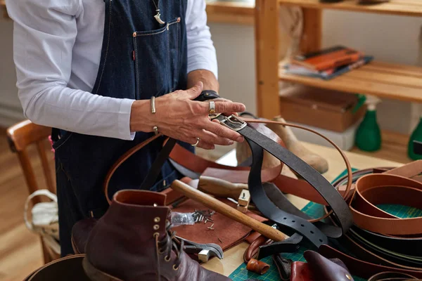 Профессиональный ремесленник кожаных ремней на работе в винтажной мастерской — стоковое фото
