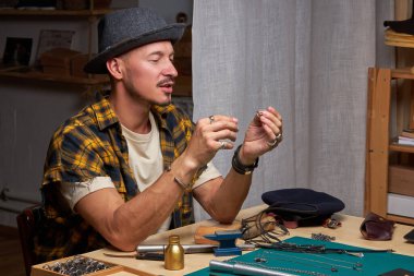 Yetenekli genç kuyumcu atölyede el yapımı bir mücevher üzerinde çalışıyor.