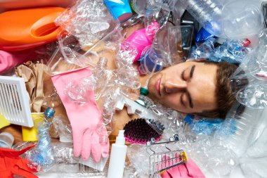 Kafkasyalı sakin bir adam boş plastik şişeler ve çöplerle uzanıyor.