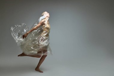 Plastik bir torba içindeki kadın, plastik çöpten kurtuluyor.