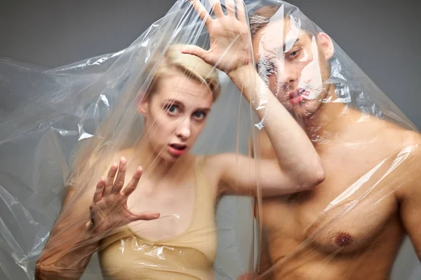 Portrait of hopelessness couple wrapped with disposable plastic bags — Stock Photo, Image