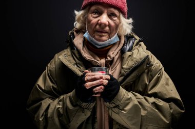 Para yardımı yapabilen evsiz yaşlı kadın portresi.