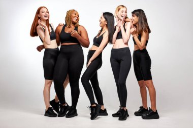 Beden kıyafetli, gülümseyen beş kadının portresi yan yana duruyor.