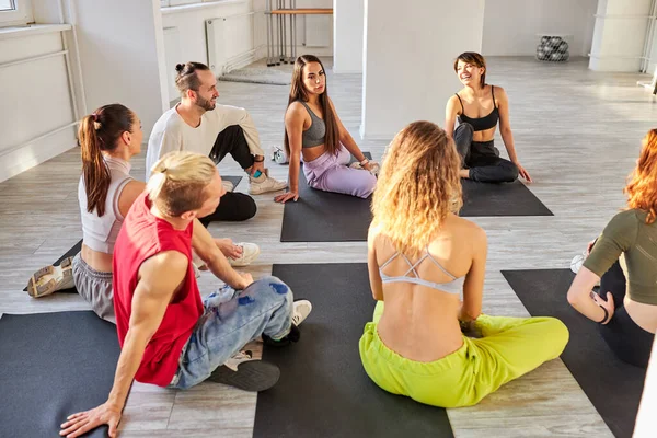 Groep jongeren zitten op de vloer met rust na de dans van yoga — Stockfoto
