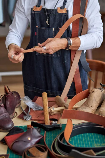 Tailleur en tablier travaillant avec ceinture en cuir à l'atelier, artisan — Photo