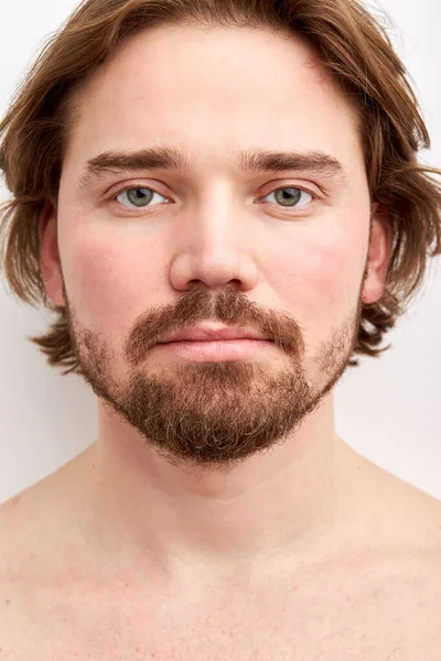 Close-up portrait of young caucasian shirtless male with long hair and beard posing at camera — Stock Photo, Image