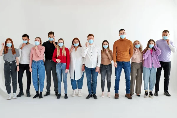 Personas que usan mascarilla médica, de pie en una fila — Foto de Stock