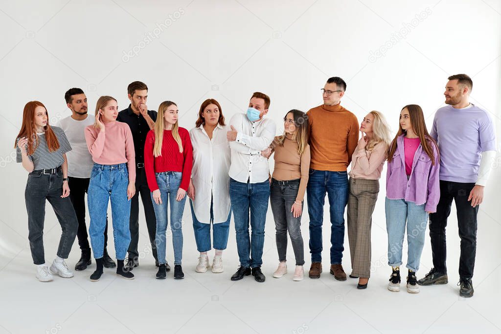infected male in medical mask stand among healthy people