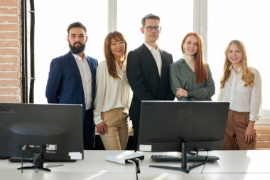 Kameraya poz veren pozitif çok ırklı iş ekibi