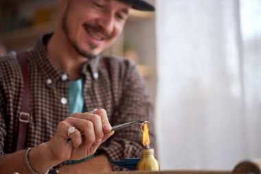 Profesyonel kuyumcu atölyede yüzük dekorasyonu yapıyor, onu kuruyor ve parlatıyor.