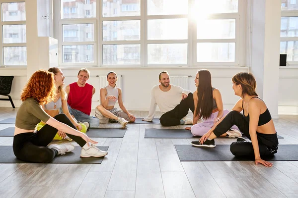Groep jongeren zitten op de vloer met rust na de dans van yoga — Stockfoto