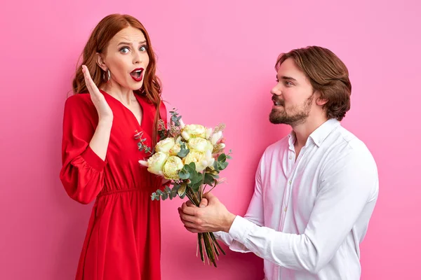 Excited young couple in party outfit posing isolated on pastel pink background, Valentines Day — Stock Photo, Image
