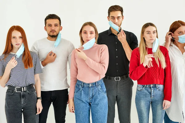 Hombres y mujeres con máscaras deshacerse de las máscaras médicas — Foto de Stock