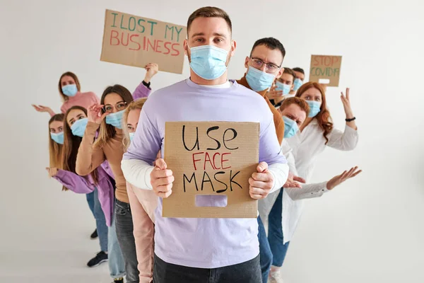 Homens e mulheres em máscaras médicas pedindo que as pessoas usem máscaras se protejam de COVID-19 — Fotografia de Stock