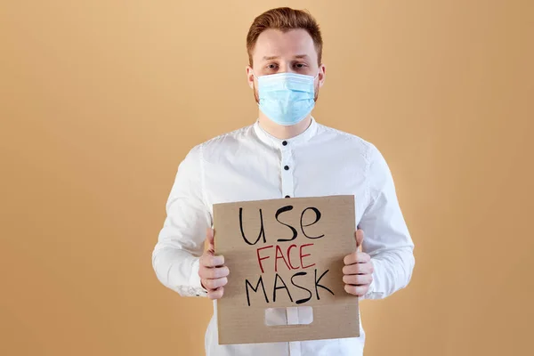 Seriös stilig man i medicinsk mask ber människor att använda masker — Stockfoto