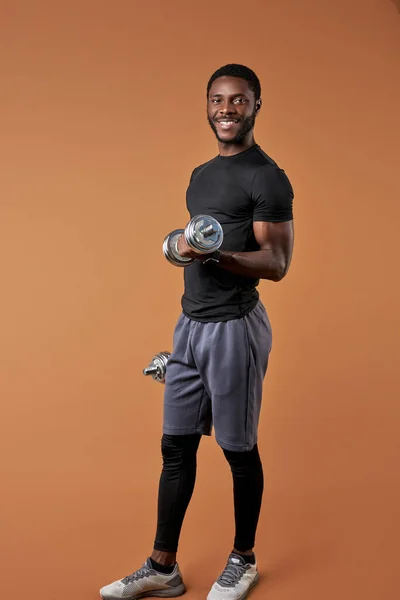Esportivo com halteres posando na câmera isolada — Fotografia de Stock