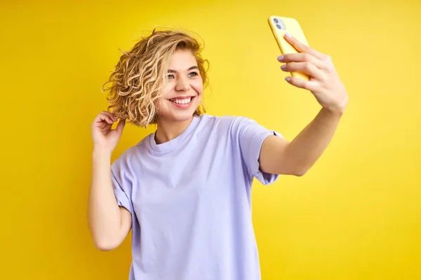 Opgewonden blond kortharige blanke vrouw poseren maken van foto op smartphone, selfie — Stockfoto