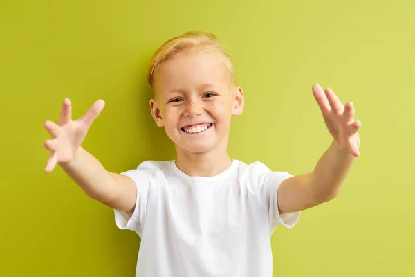 Портрет симпатичного маленького белого мальчика с веснушками, расправляющими руки, пытающегося обнять друга в школе — стоковое фото