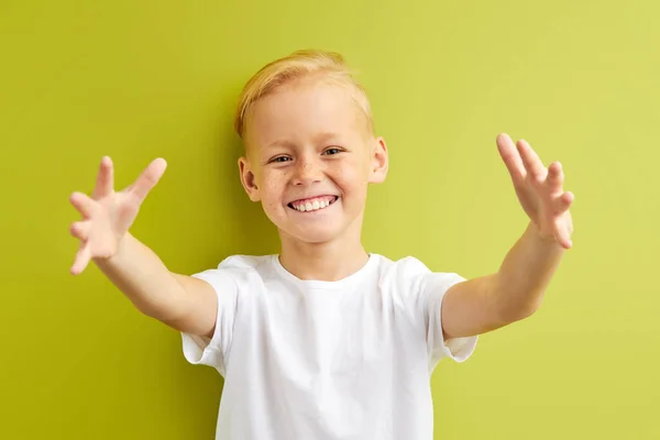 Portret van mooie kleine Kaukasische jongen met sproeten verspreiden van handen, proberen te knuffelen vriend op school — Stockfoto